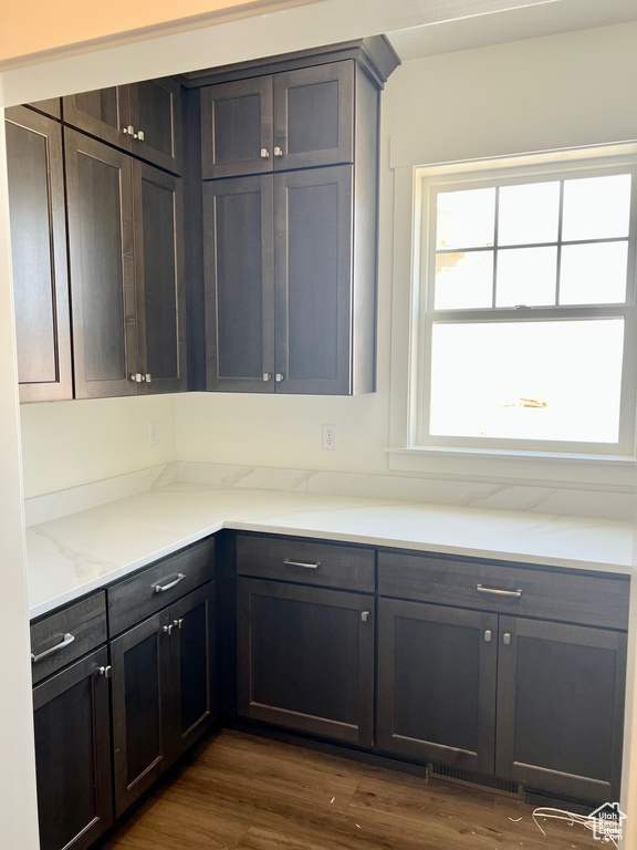 Kitchen featuring dark wood-type flooring and light stone counters