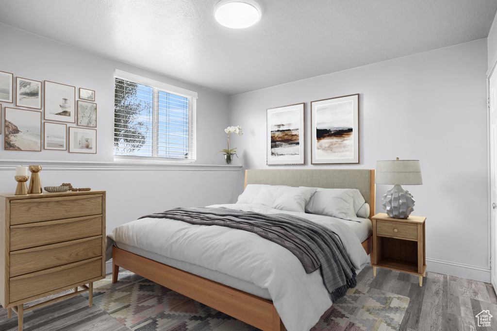 Bedroom with wood finished floors and baseboards