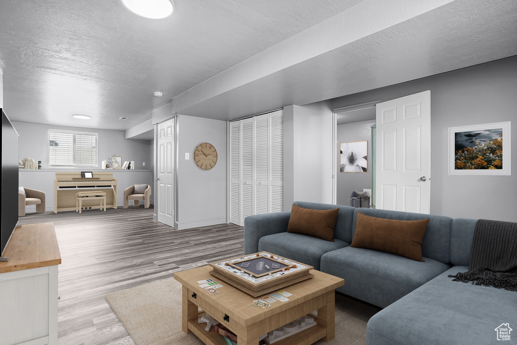 Living room featuring a textured ceiling, wood finished floors, and baseboards
