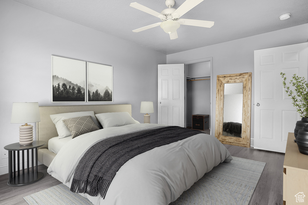 Bedroom with wood finished floors, a closet, ceiling fan, and baseboards