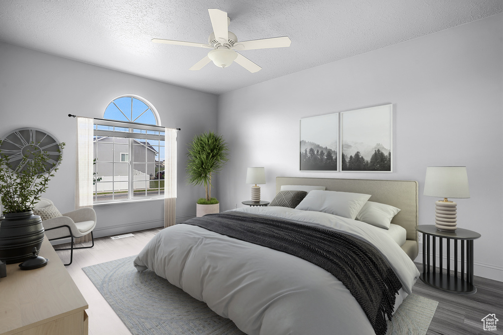 Bedroom featuring wood finished floors, a textured ceiling, baseboards, and a ceiling fan