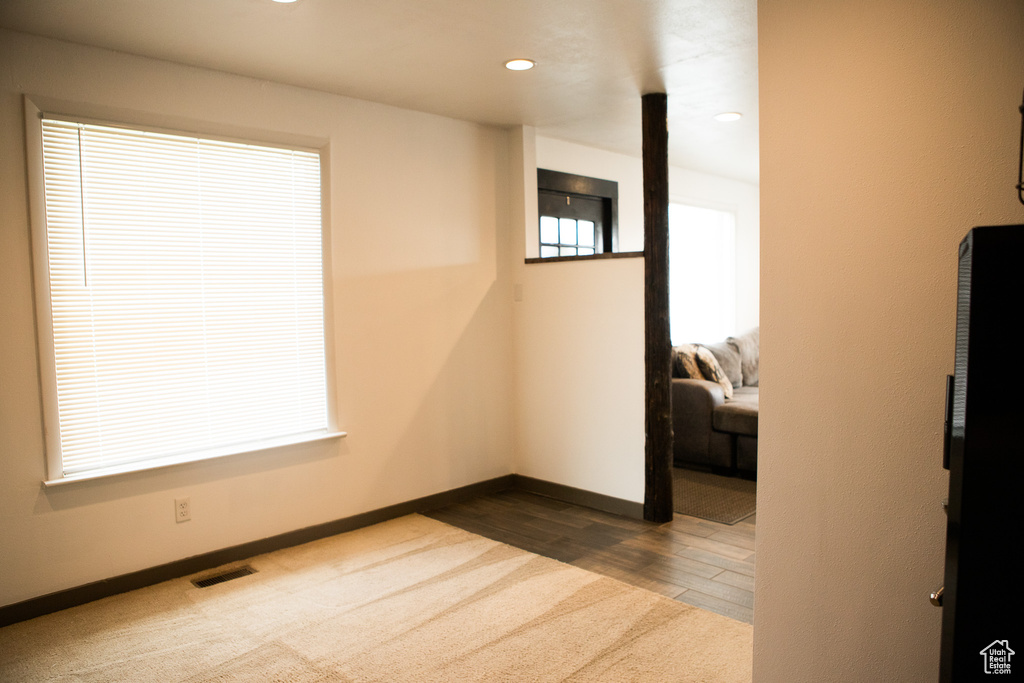 Empty room featuring baseboards, dark colored carpet, recessed lighting, and dark wood finished floors