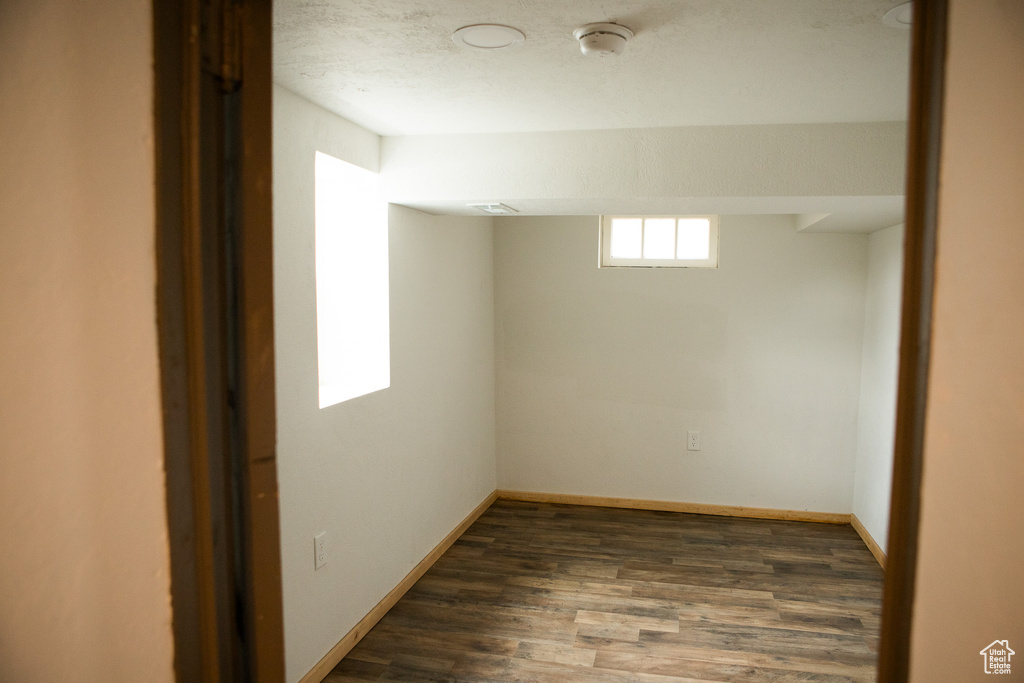 Below grade area featuring dark wood-type flooring and baseboards