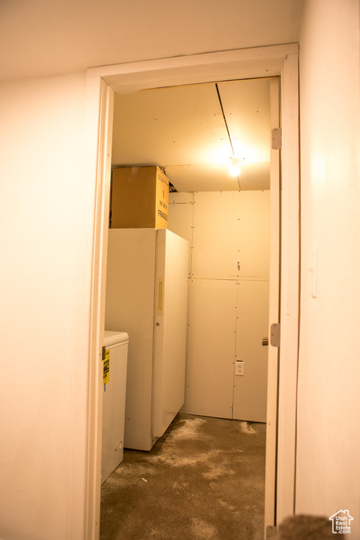 Below grade area featuring freestanding refrigerator
