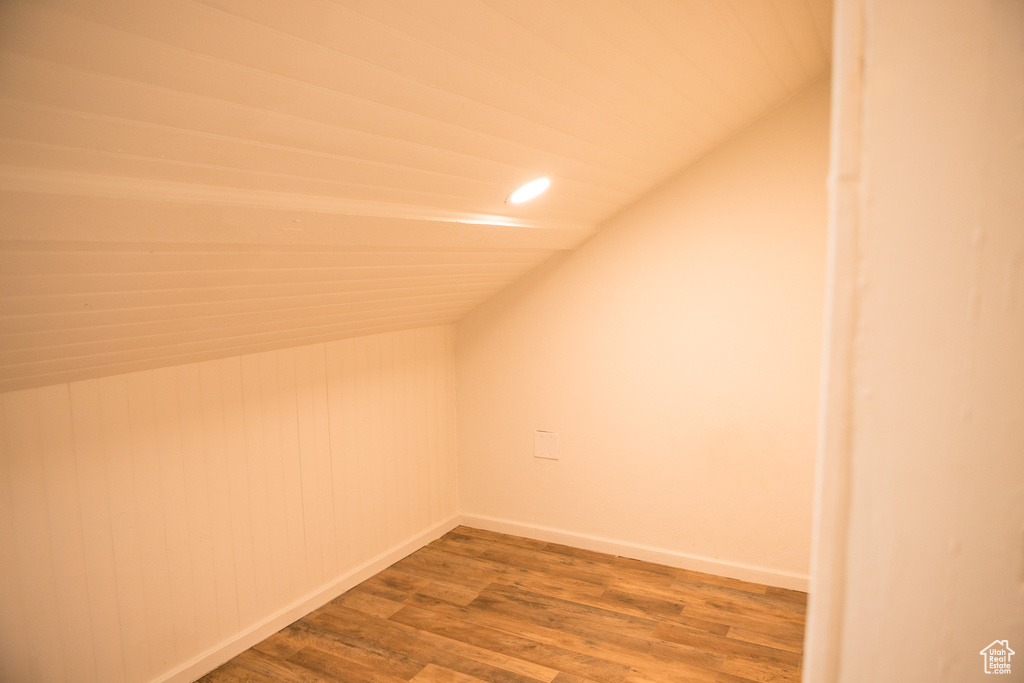 Additional living space with lofted ceiling, wood finished floors, baseboards, and recessed lighting