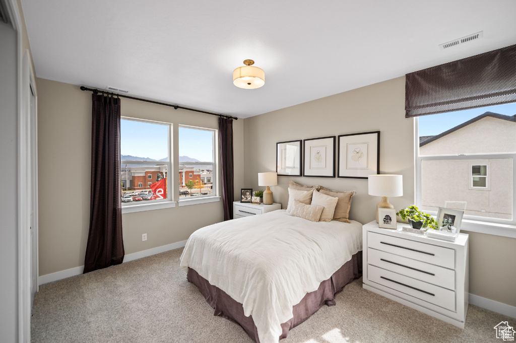 Bedroom featuring light colored carpet and baseboards