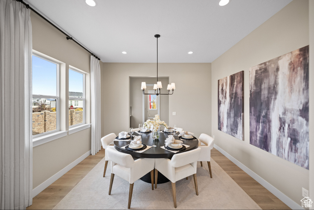 Dining area with a chandelier, recessed lighting, light wood-style floors, and baseboards