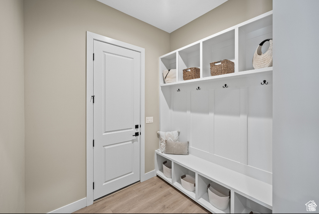 Mudroom featuring light wood-style floors and baseboards