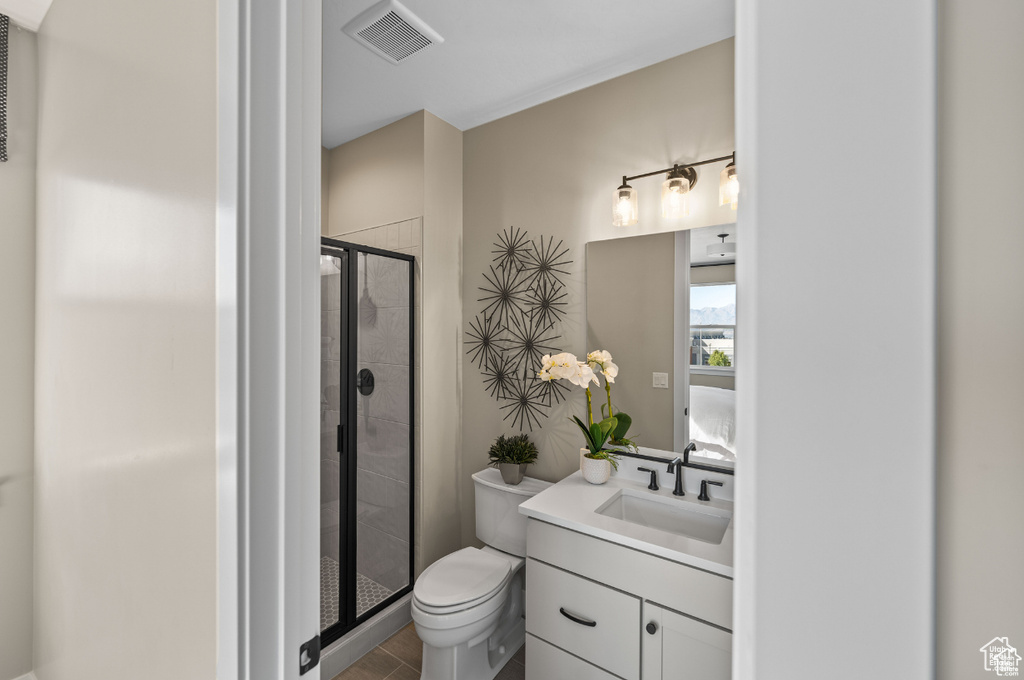 Full bathroom featuring a shower stall, vanity, and toilet