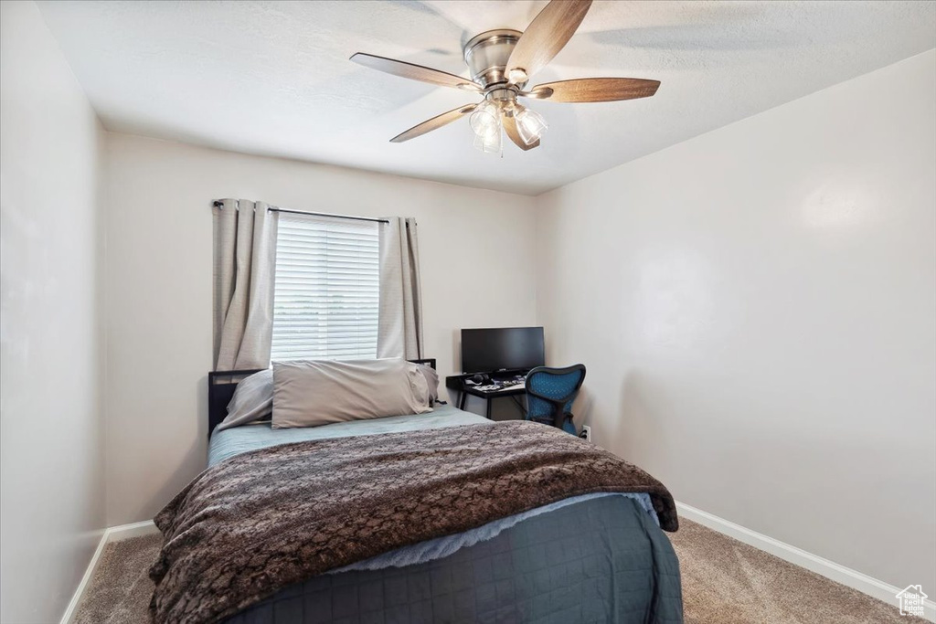 Carpeted bedroom with baseboards and ceiling fan