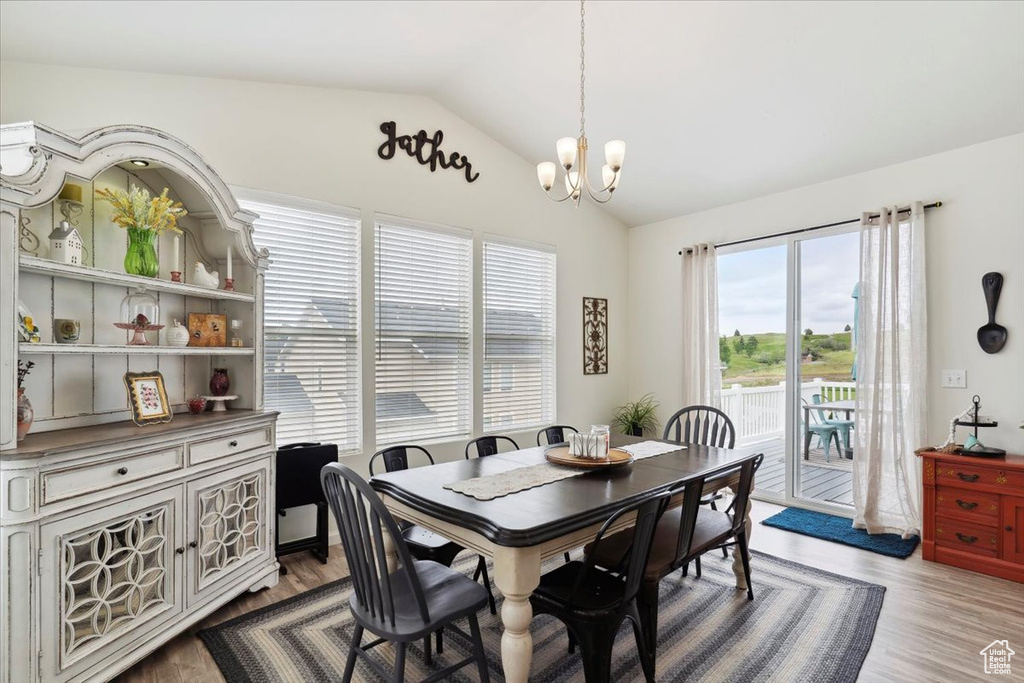 Dining room featuring a chandelier, vaulted ceiling, and wood finished floors