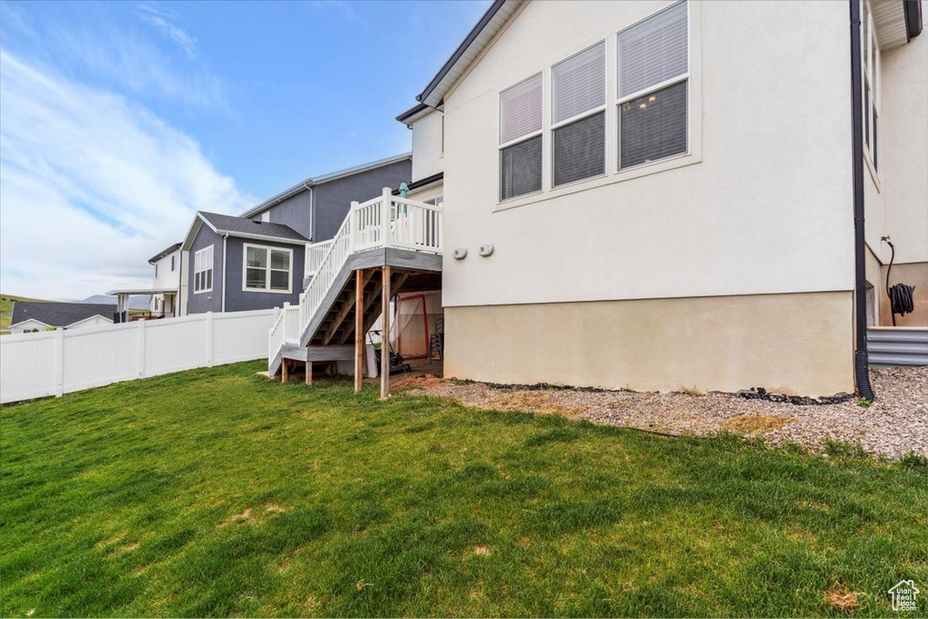 Back of house with stairs, a deck, and stucco siding