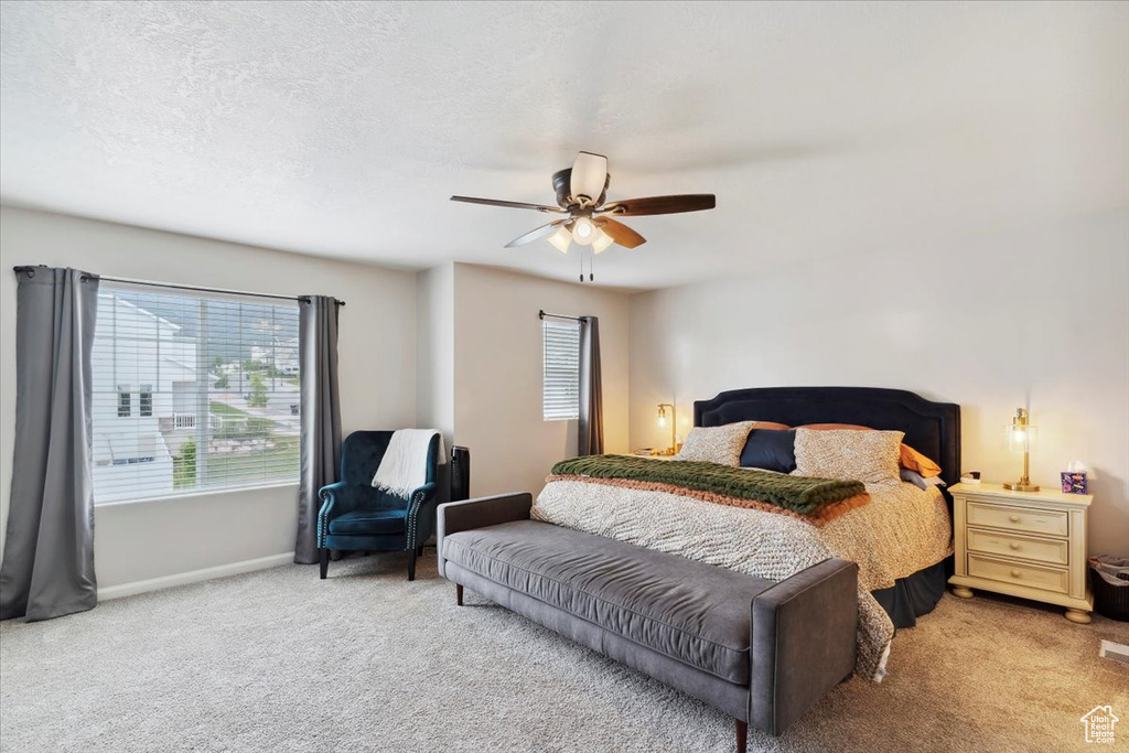Carpeted bedroom with baseboards and a ceiling fan