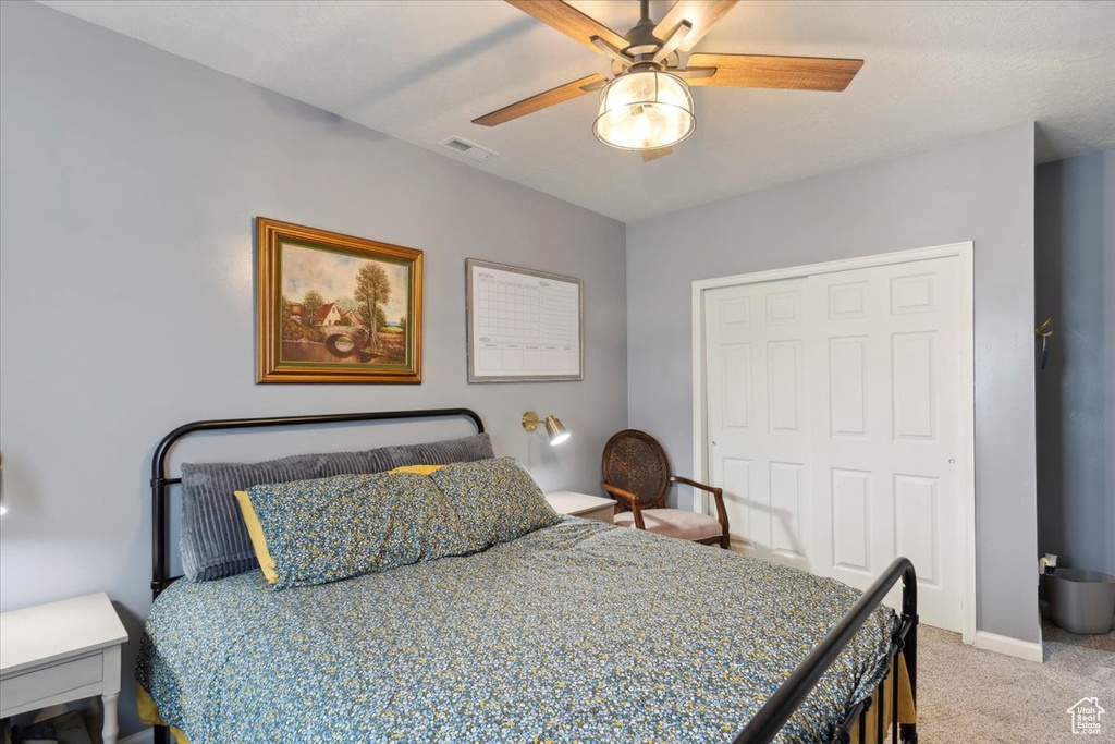 Bedroom featuring light carpet, a closet, ceiling fan, and baseboards