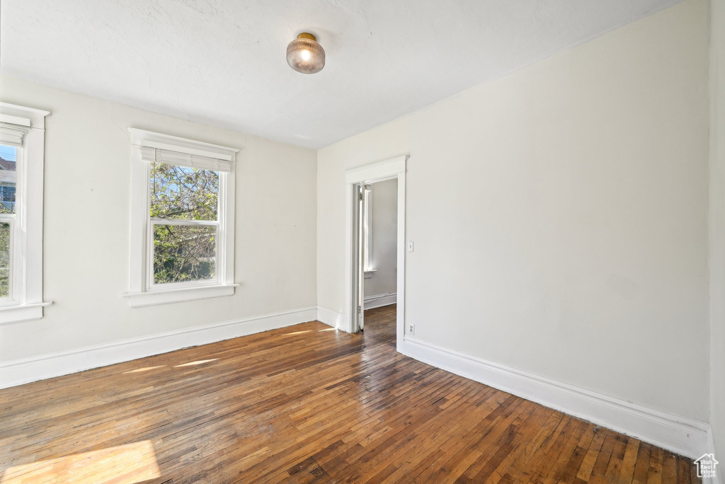 Spare room featuring hardwood / wood-style flooring and baseboards