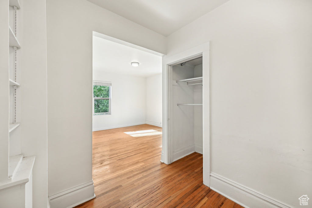 Unfurnished bedroom with light wood-type flooring, baseboards, and a closet