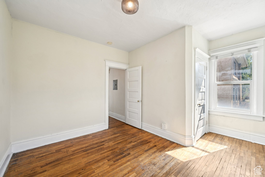 Unfurnished room featuring hardwood / wood-style floors and baseboards