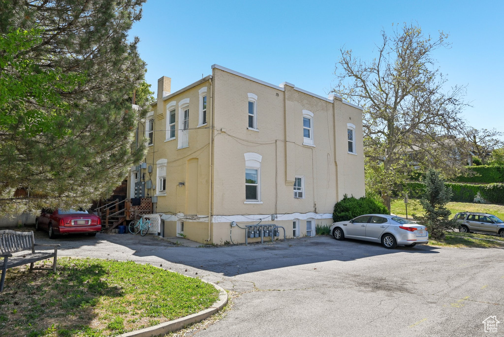View of property exterior featuring uncovered parking and a chimney