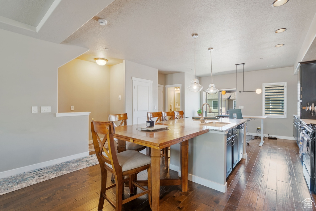 Kitchen featuring a sink, dark wood-type flooring, baseboards, recessed lighting, and a textured ceiling