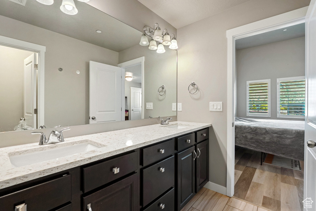 Ensuite bathroom with double vanity and wood finished floors