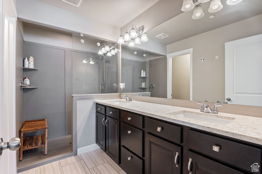 Bathroom featuring double vanity and a walk in shower