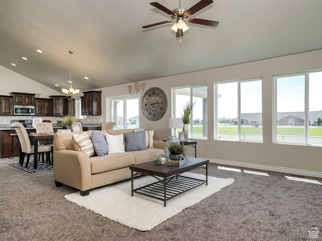 Living room with a chandelier, ceiling fan, recessed lighting, carpet flooring, and high vaulted ceiling