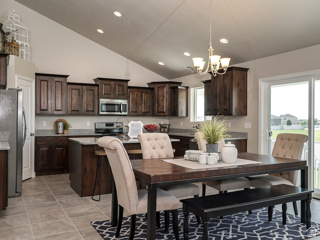 Dining area with a chandelier, recessed lighting, plenty of natural light, light tile patterned flooring, and vaulted ceiling