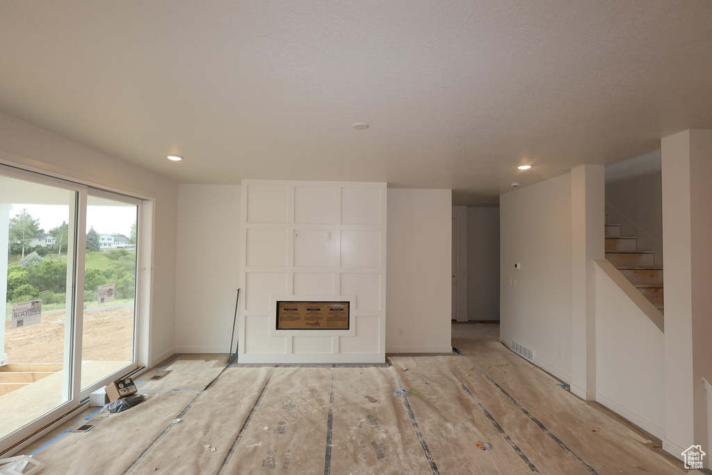 Unfurnished living room with recessed lighting and stairway