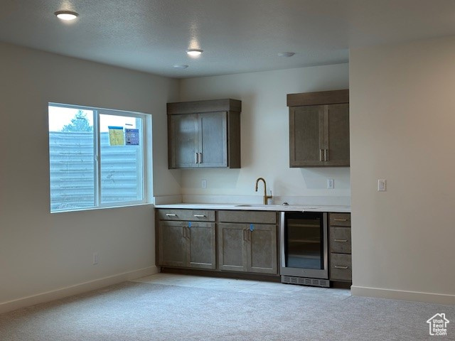 Bar featuring wine cooler and light colored carpet