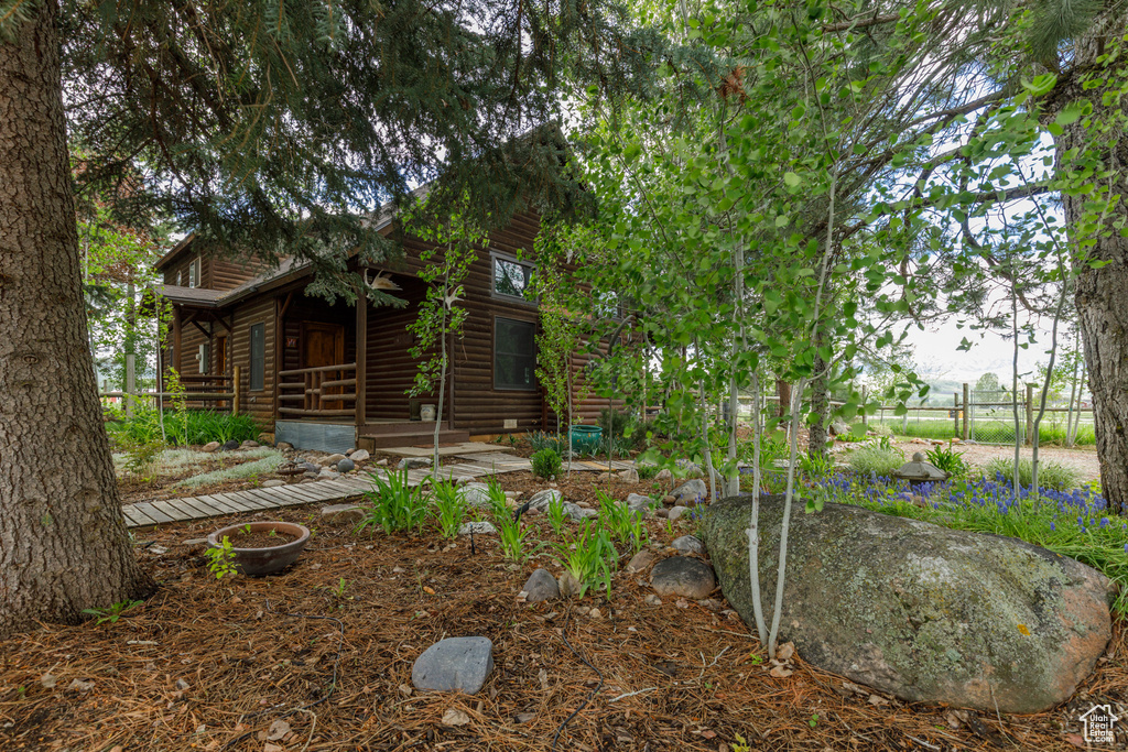 View of front of house featuring faux log siding and covered porch