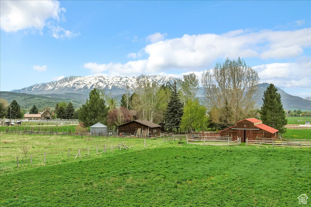 View of yard with an exterior structure, an outbuilding, a rural view, a mountain view, and a pole building