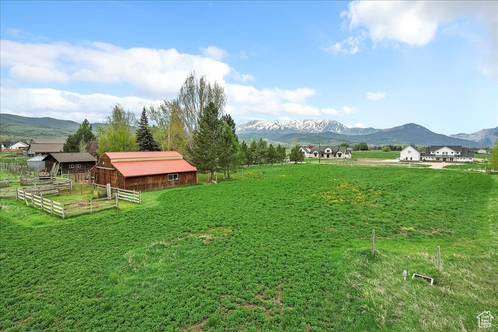 View of yard with a mountain view, an outbuilding, and a rural view