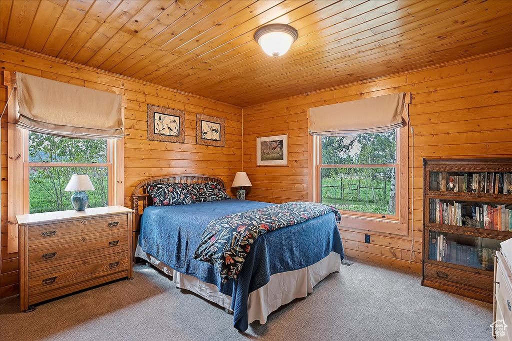 Bedroom featuring carpet flooring, wood ceiling, and wooden walls