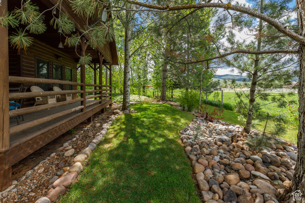 View of grassy yard featuring a deck