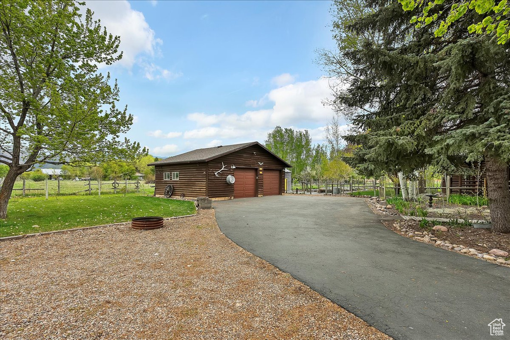 View of side of property with an outbuilding and a detached garage