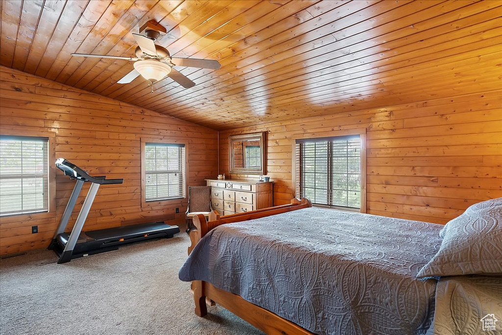 Bedroom featuring multiple windows, wood ceiling, carpet, vaulted ceiling, and wood walls