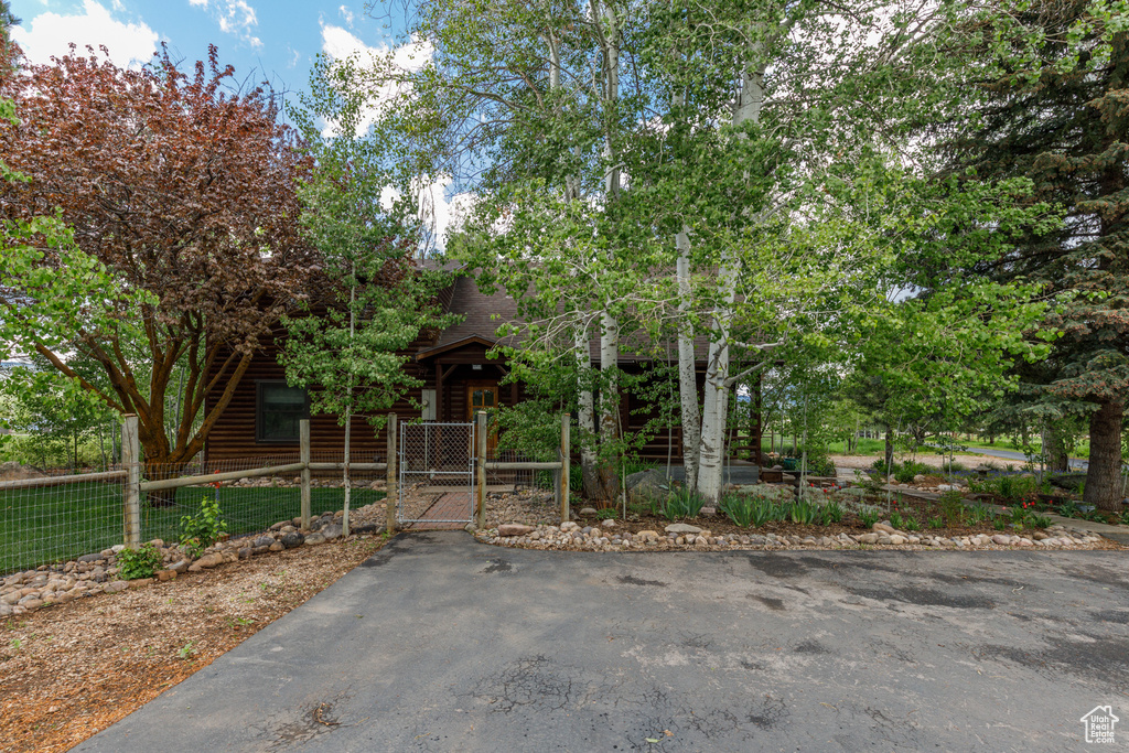 View of front of house with a gate, a fenced front yard, and a shingled roof