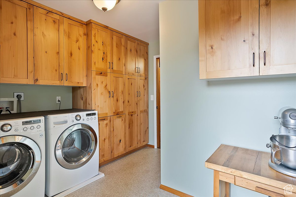 Laundry area with cabinet space, washing machine and clothes dryer, and baseboards