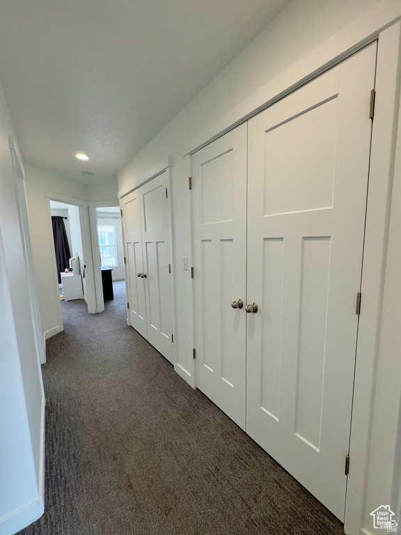 Hall featuring dark carpet, baseboards, and recessed lighting
