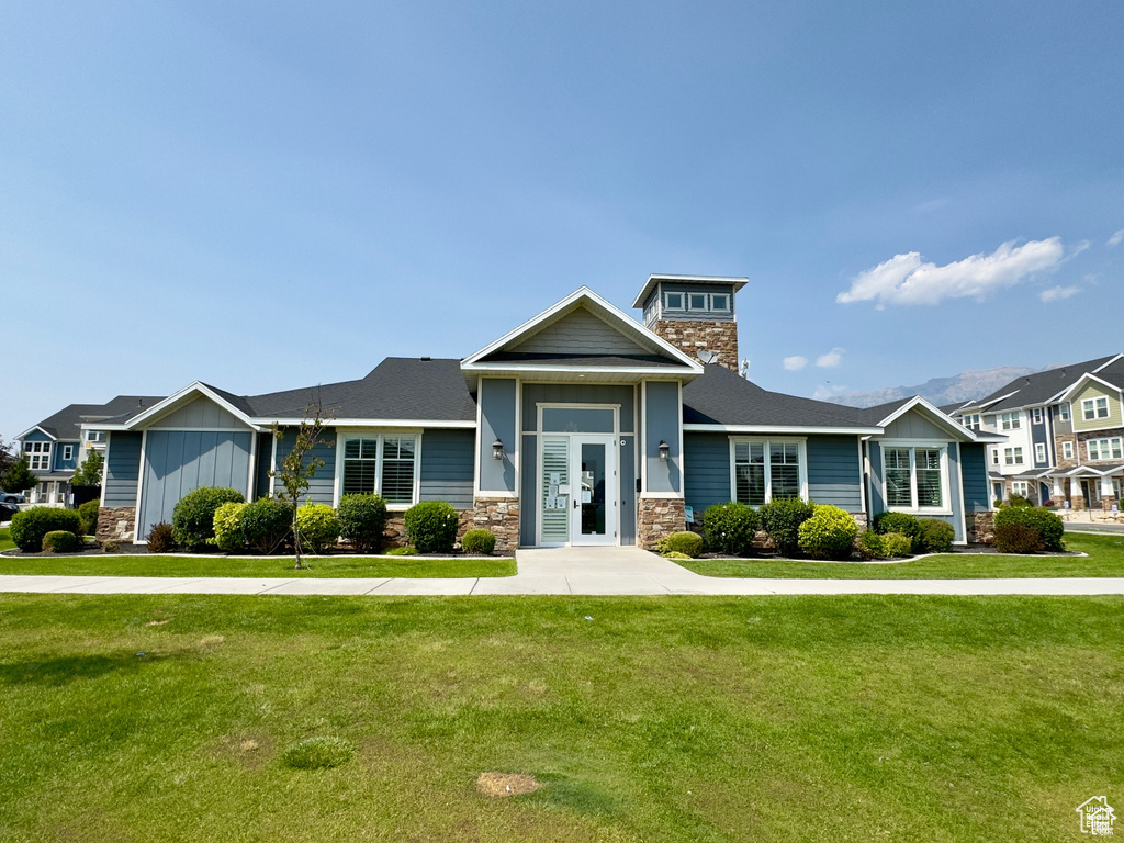 View of front of house with stone siding and a front lawn