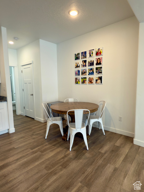 Dining area featuring dark wood-type flooring, baseboards, and recessed lighting