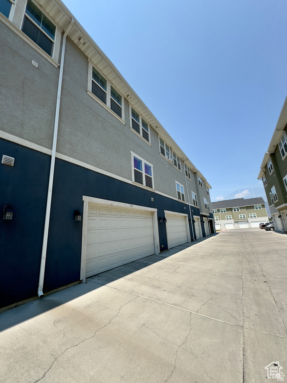 View of building exterior with a residential view and a garage