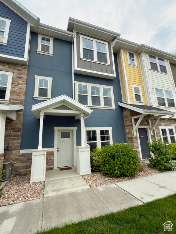 View of property featuring stone siding, stucco siding, and board and batten siding