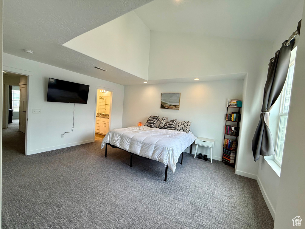 Bedroom with carpet floors, baseboards, lofted ceiling, ensuite bath, and recessed lighting