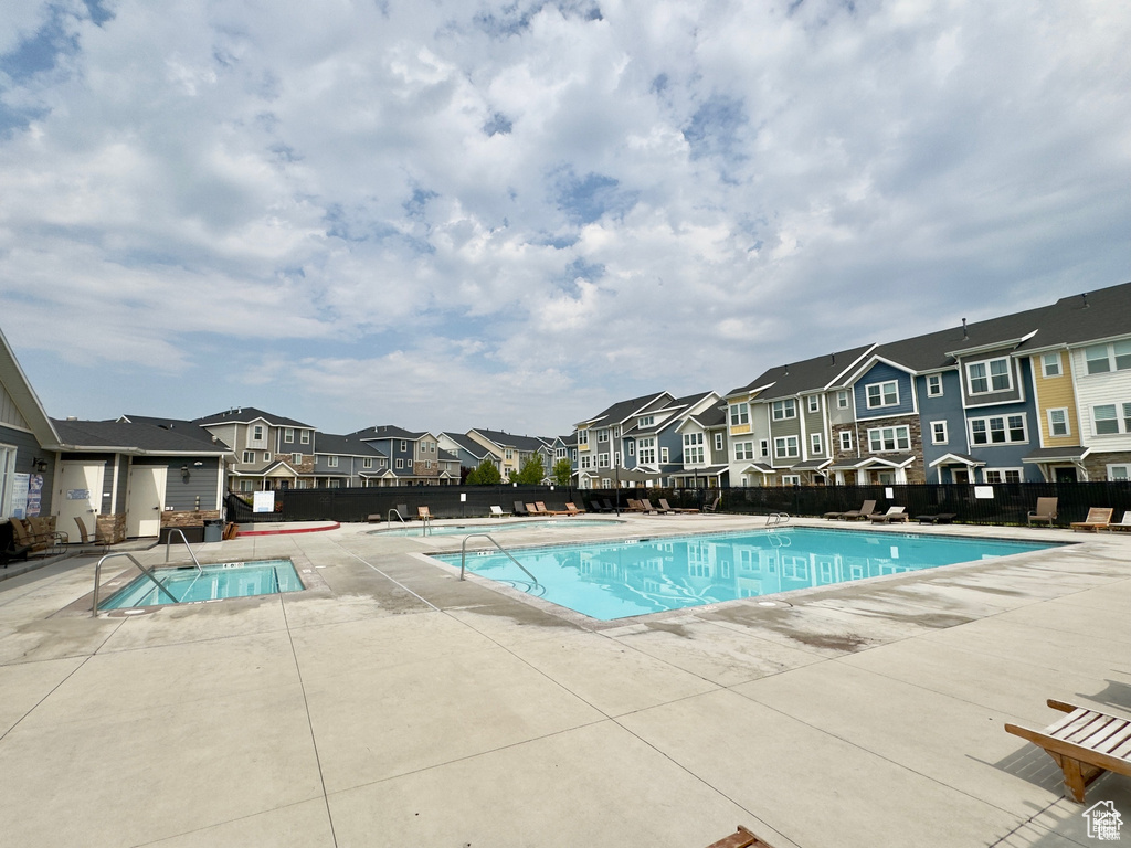 Community pool featuring a residential view, fence, and a patio area