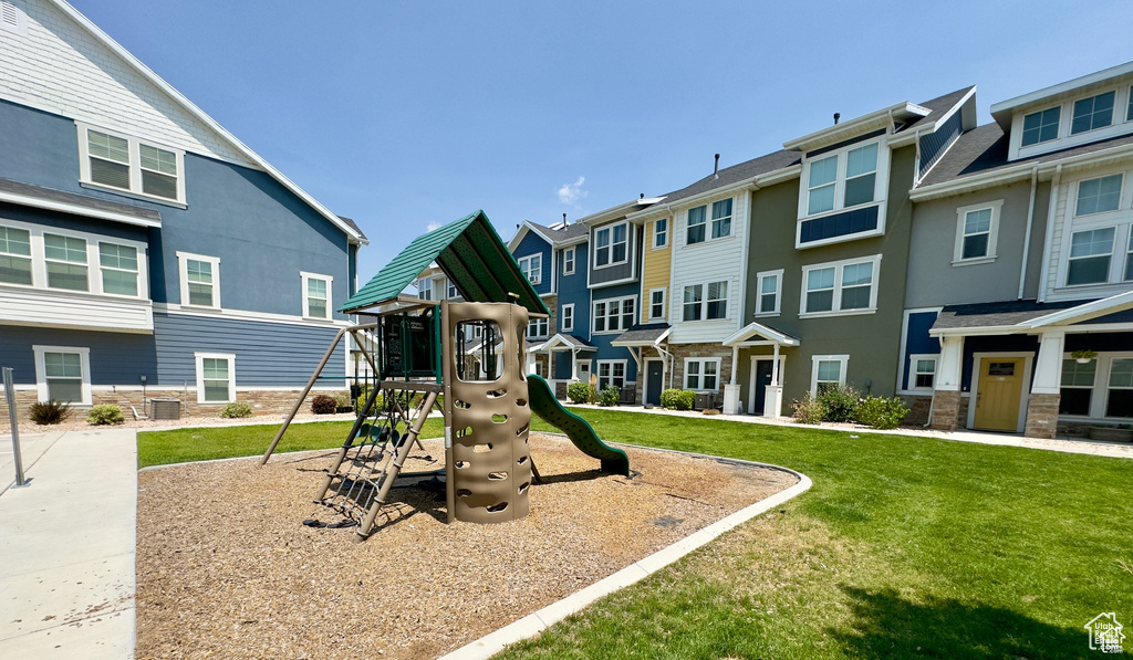 Community play area featuring a residential view, a lawn, and cooling unit