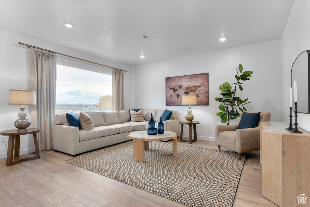 Living area with light wood finished floors, baseboards, and recessed lighting
