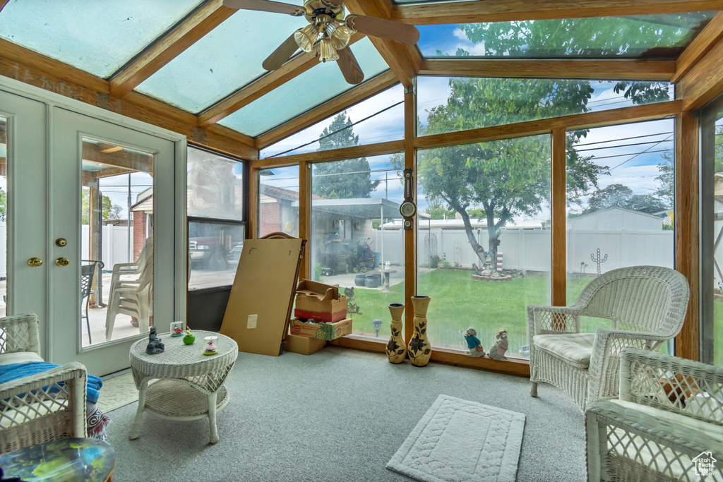 Sunroom with a ceiling fan and lofted ceiling