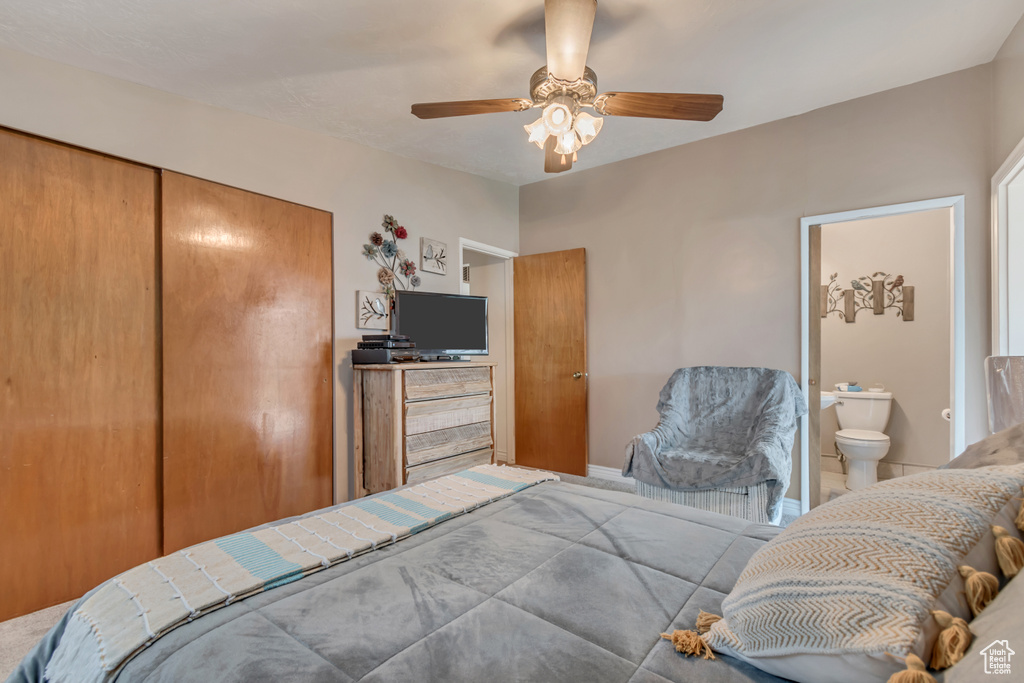Bedroom with a closet, connected bathroom, and ceiling fan