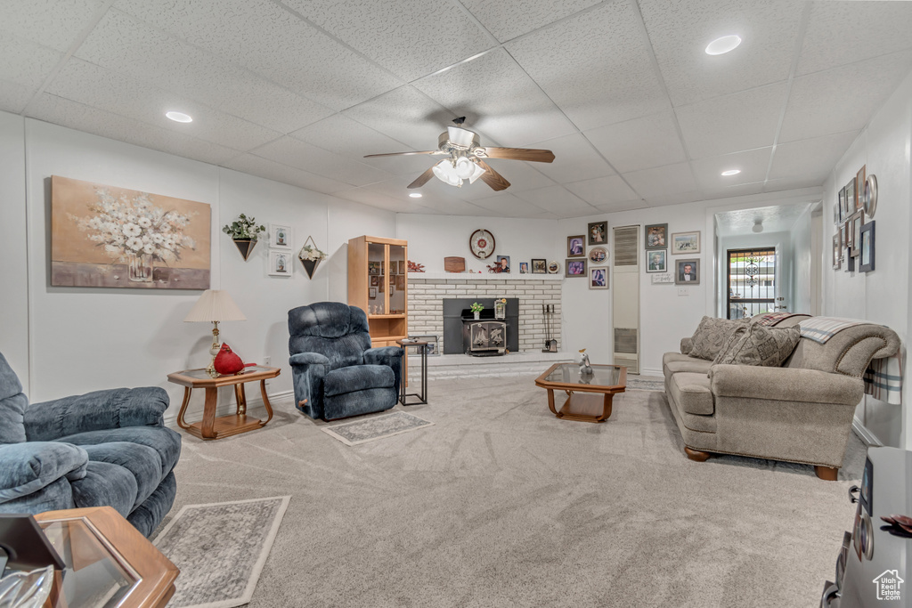 Carpeted living area featuring a ceiling fan, recessed lighting, and a paneled ceiling